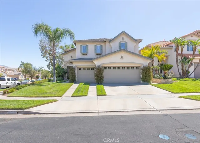 a front view of a house with a yard and potted plants