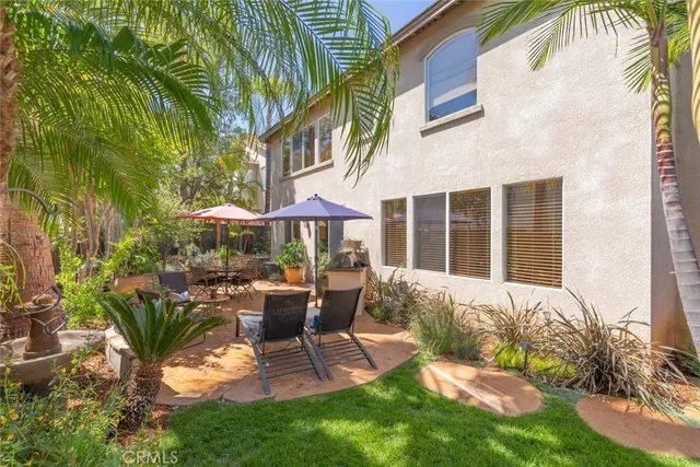 a view of a patio with a table and chairs under an umbrella