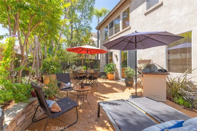 a view of patio with chairs and table under an umbrella
