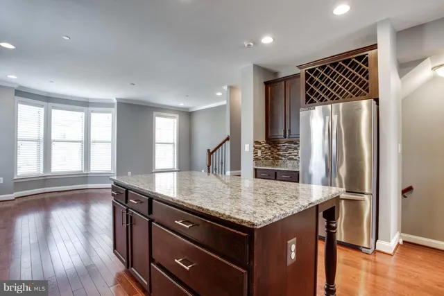a kitchen with a refrigerator and wooden floor