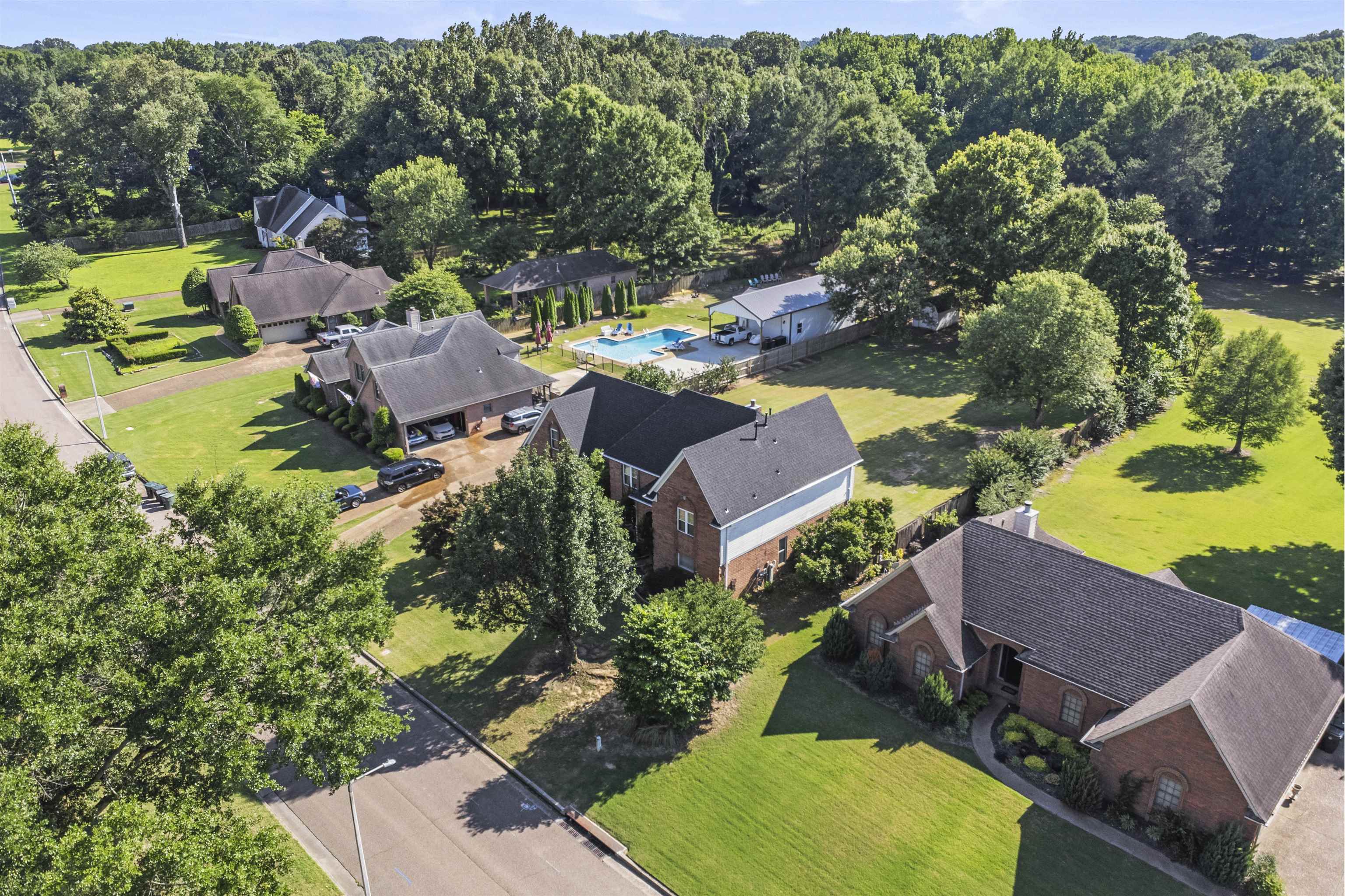 4279 High Plains Road Bartlett, TN 38135 - Photo 32 of 37 Brick residence featuring a prominent front entrance, expansive green lawns, mature trees, and a paved driveway