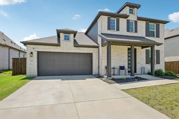 a front view of a house with yard and parking