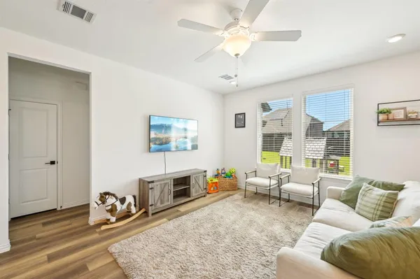 a living room with furniture ceiling fan and a rug