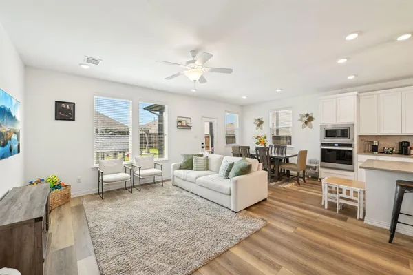 a living room with furniture kitchen view and a chandelier