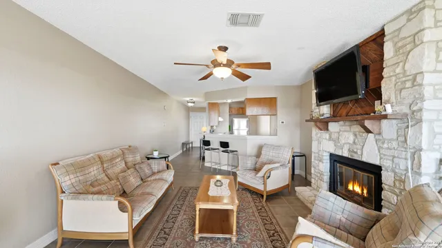 a living room with furniture a flat screen tv and a fireplace