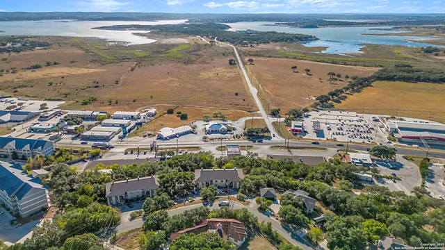 an aerial view of residential houses with outdoor space and trees