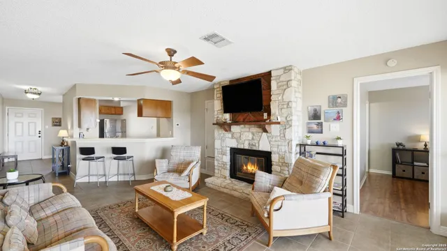a living room with furniture a fireplace and a flat screen tv