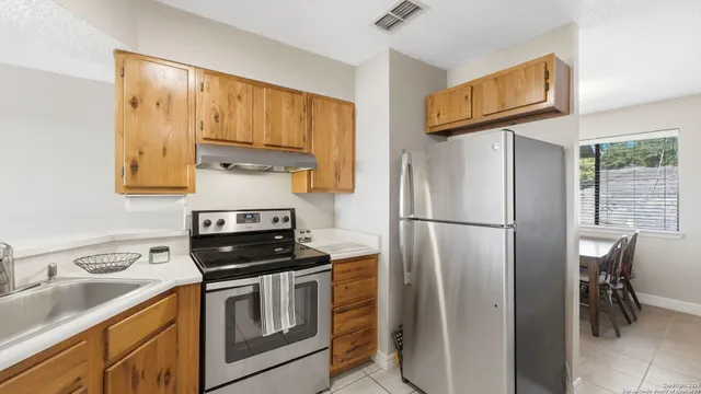 a kitchen with stainless steel appliances a refrigerator sink and stove