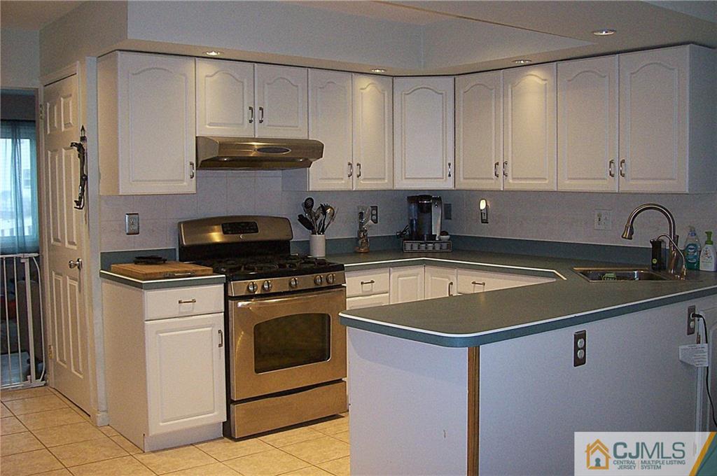 23 Rodney Road East Brunswick, NJ 08816 - Photo 8 of 25 a kitchen with granite countertop white cabinets and stainless steel appliances