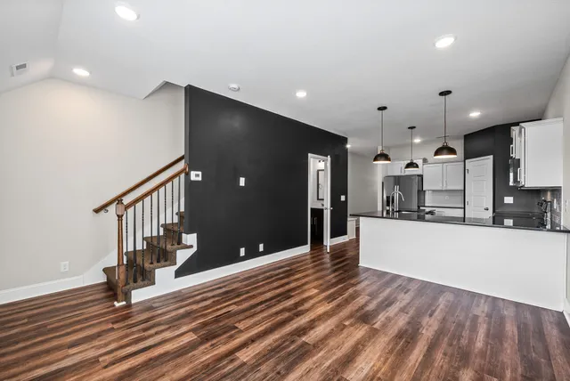 a view of a hallway with wooden floor and staircase