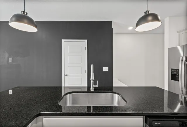 a view of a kitchen with a sink and chandelier