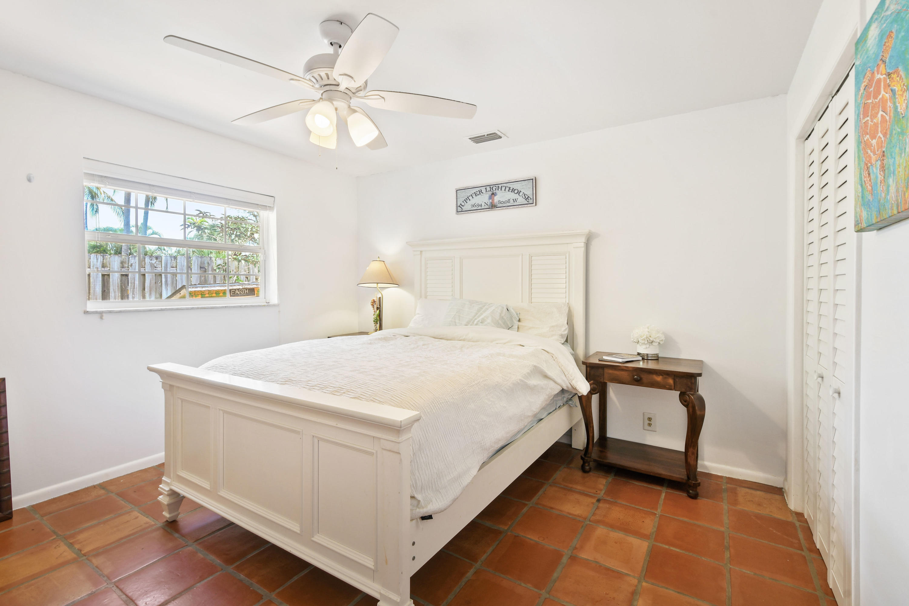 19943 Pinetree Drive Jupiter, FL 33469 - Photo 22 of 42 a bedroom with a bed and a chandelier