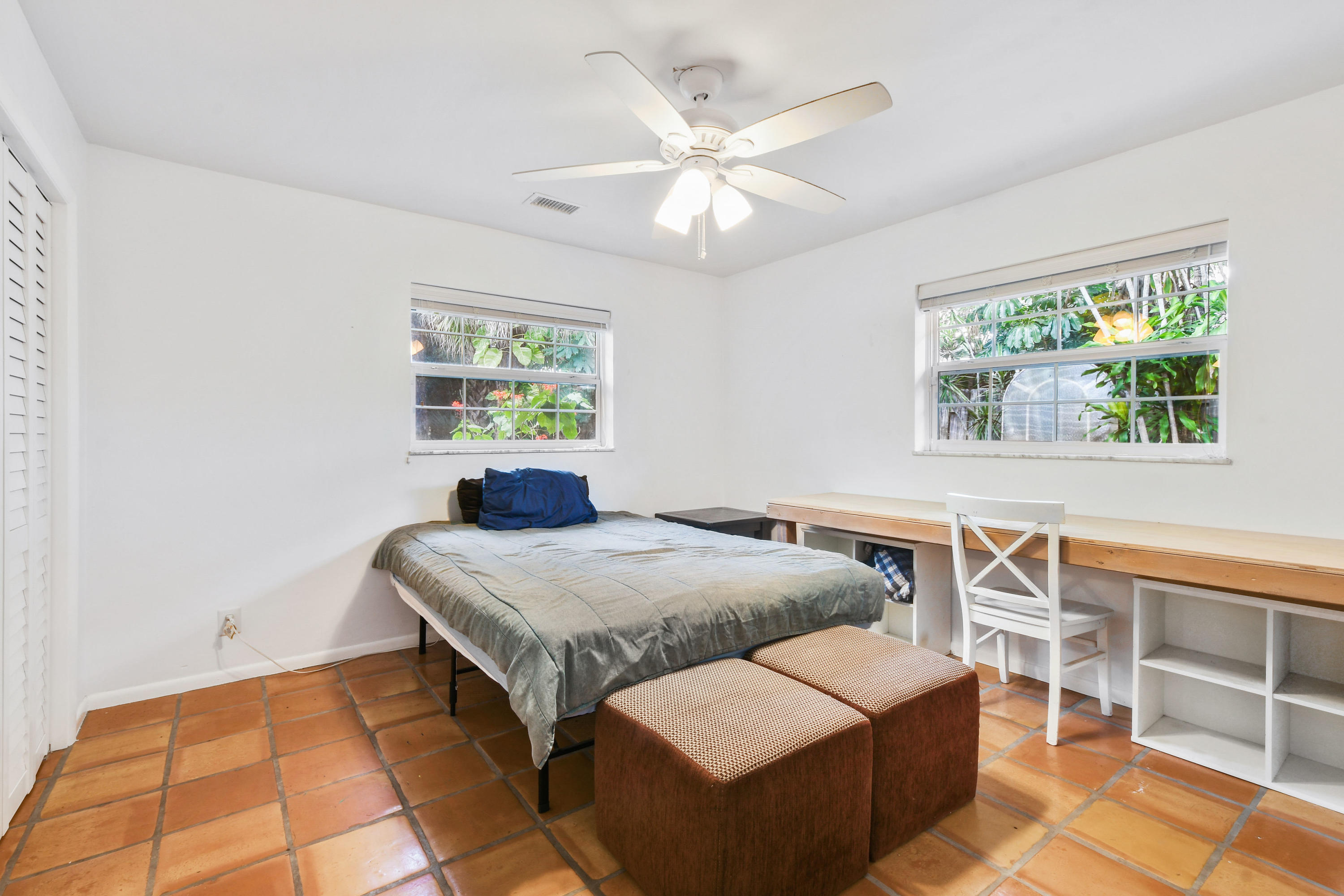 19943 Pinetree Drive Jupiter, FL 33469 - Photo 24 of 42 a bedroom with a bed and a chandelier