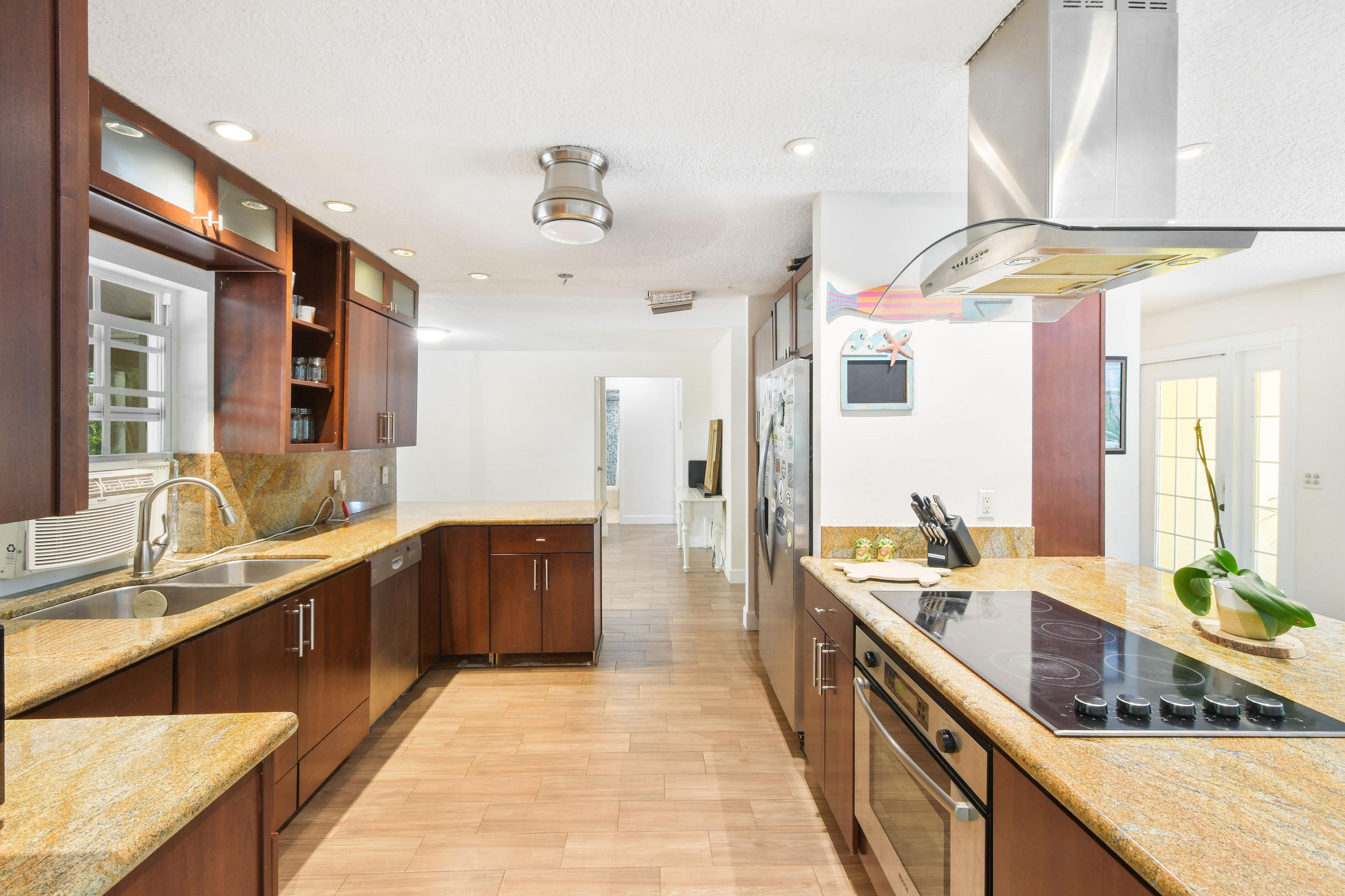 19943 Pinetree Drive Jupiter, FL 33469 - Photo 9 of 42 a large kitchen with a large counter top a sink a stove and a wooden floors
