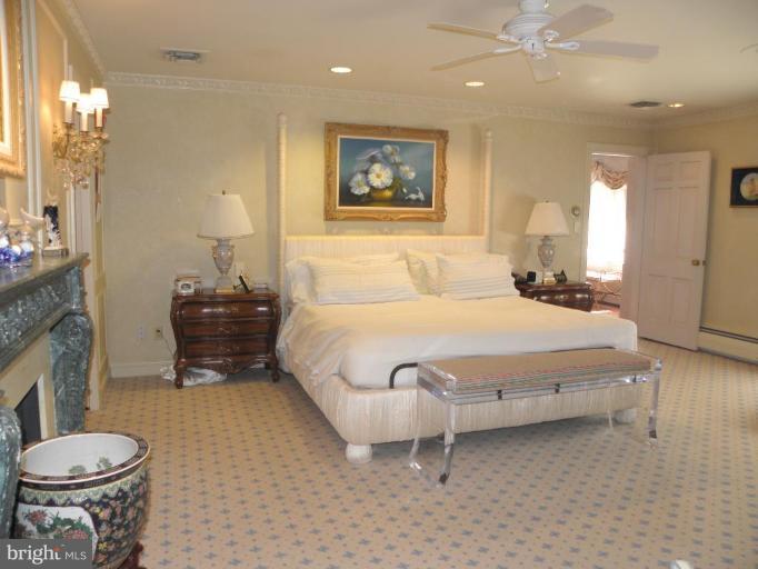 7004 Nevis Road Bethesda, MD 20817 - Photo 12 of 24 a spacious bedroom with a bed and a chandelier