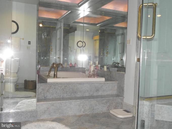 7004 Nevis Road Bethesda, MD 20817 - Photo 23 of 24 a bathroom with a shower a mirror and a sink