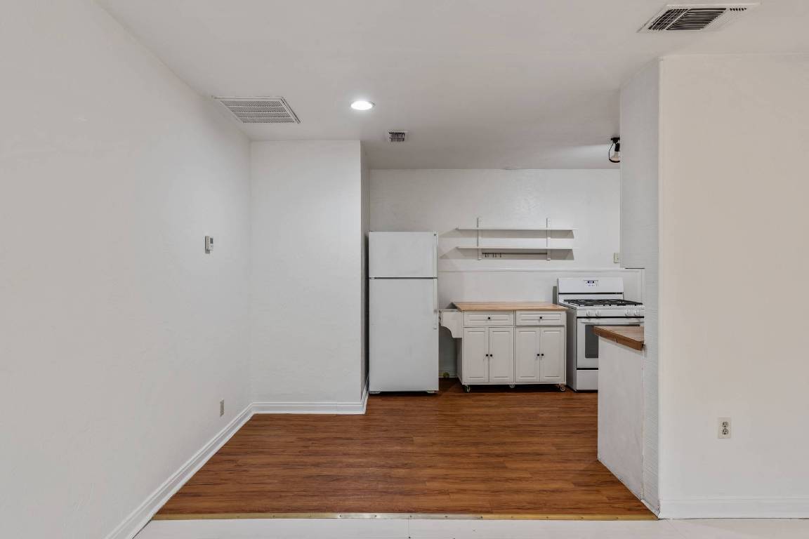 406 East Monroe Street, Unit B Austin, TX 78704 - Photo 12 of 35 Kitchen with white cabinets, white appliances, dark wood-style floors, butcher block counters, and recessed lighting
