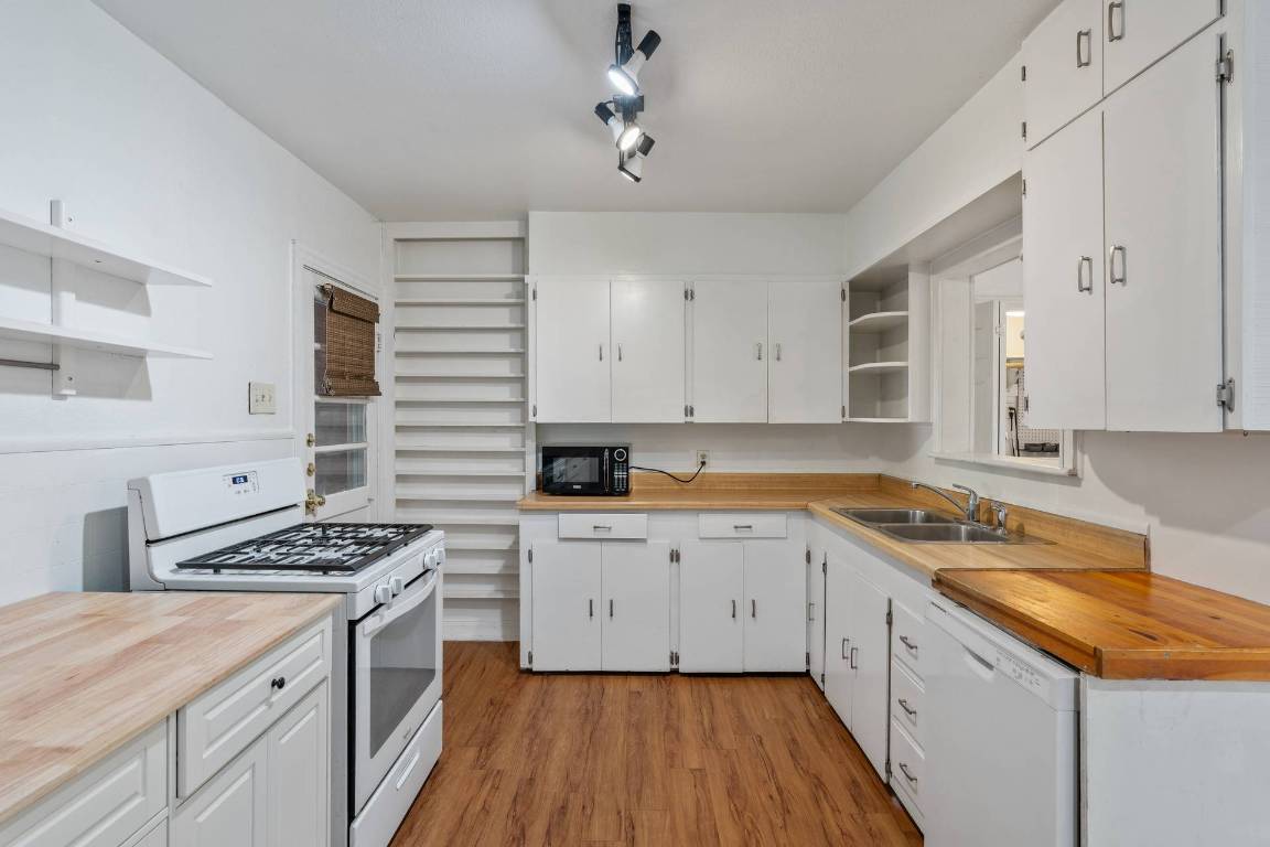 406 East Monroe Street, Unit B Austin, TX 78704 - Photo 9 of 35 a kitchen with granite countertop a sink stove and cabinets