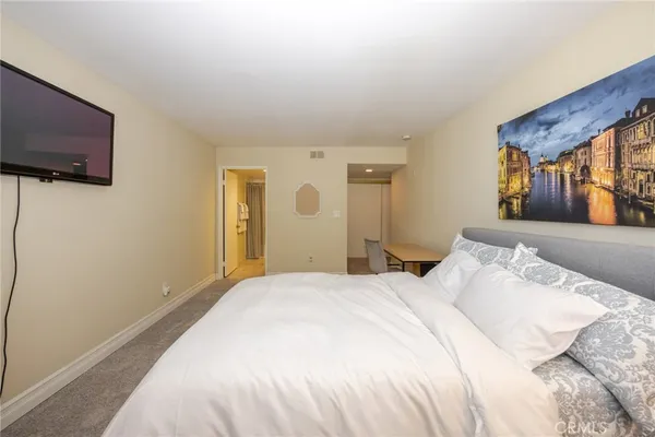 a bedroom with a bed and a flat screen tv