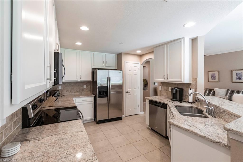 9508 Ironstone Terrace, Unit 2102 Naples, FL 34120 - Photo 11 of 50 a kitchen with a sink a refrigerator and cabinets