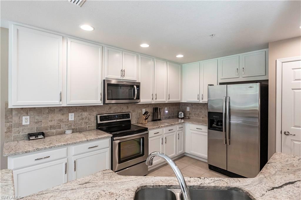 9508 Ironstone Terrace, Unit 2102 Naples, FL 34120 - Photo 12 of 50 a kitchen with a refrigerator sink and stainless steel appliances