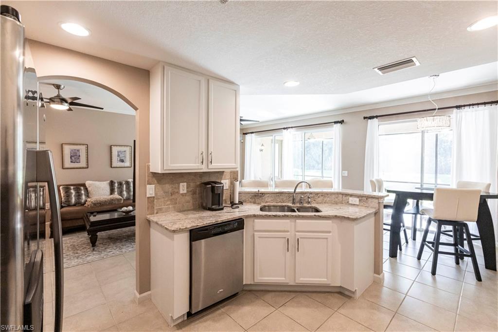 9508 Ironstone Terrace, Unit 2102 Naples, FL 34120 - Photo 13 of 50 a kitchen that has a sink and chairs