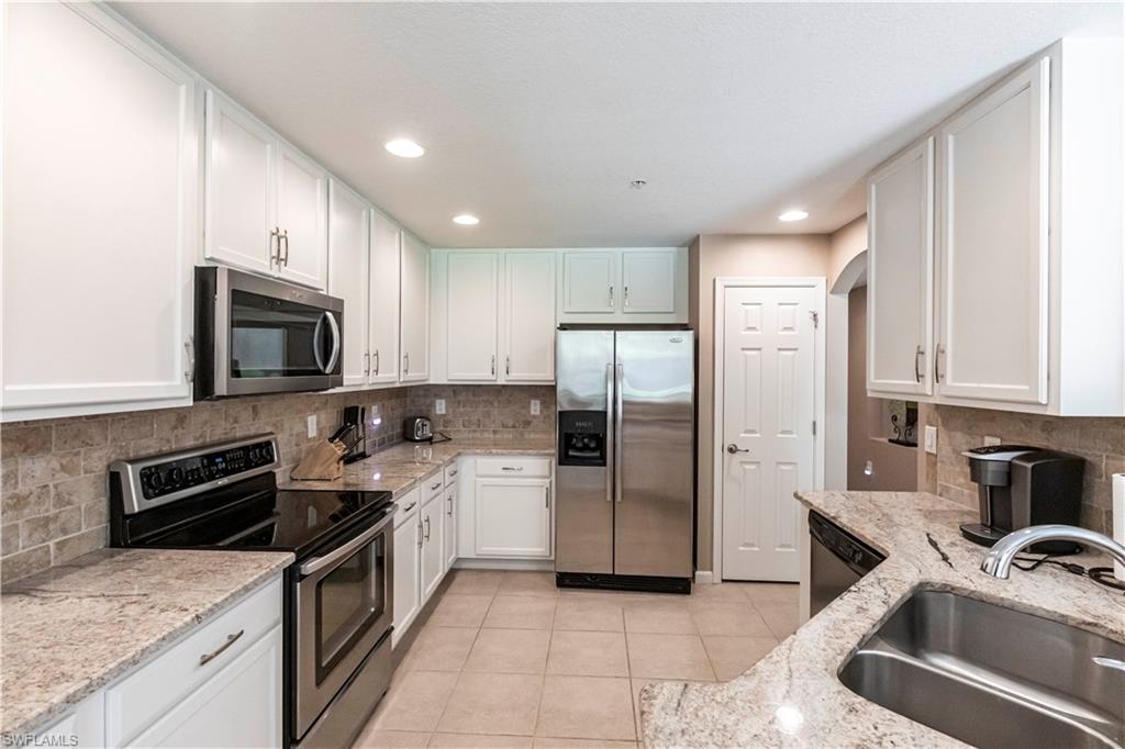 9508 Ironstone Terrace, Unit 2102 Naples, FL 34120 - Photo 14 of 50 a kitchen with a refrigerator stove and sink