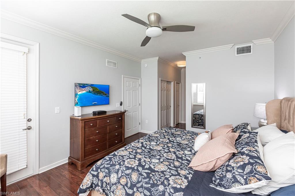 9508 Ironstone Terrace, Unit 2102 Naples, FL 34120 - Photo 20 of 50 a bedroom with a bed and a chandelier