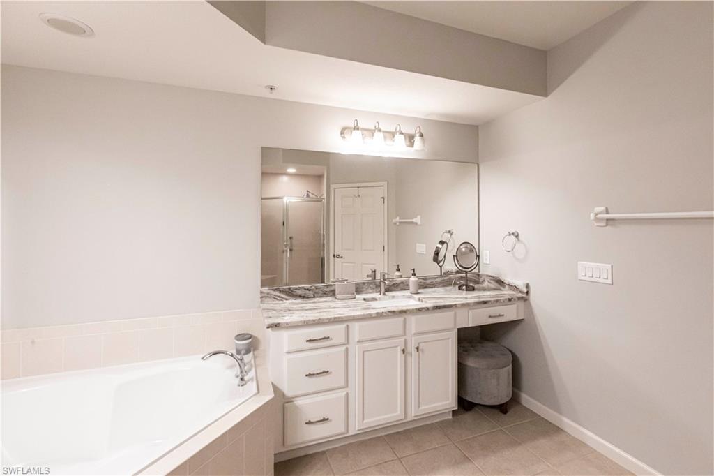 9508 Ironstone Terrace, Unit 2102 Naples, FL 34120 - Photo 22 of 50 a bathroom with a granite countertop sink double vanity and a bathtub