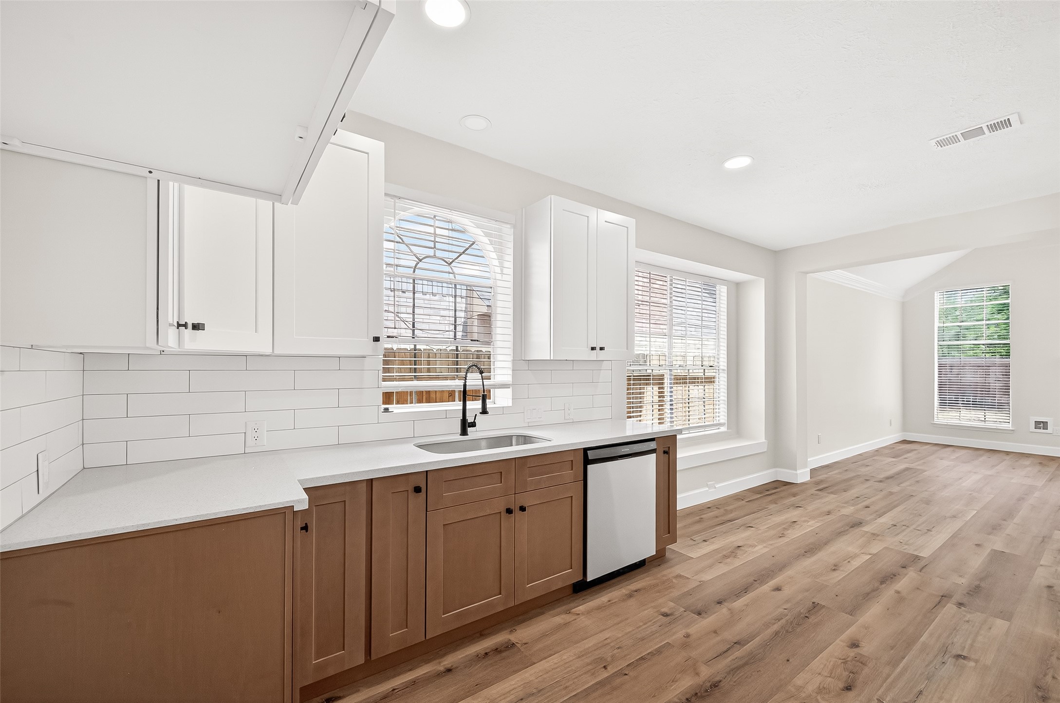 6714 Cleft Stone Drive Houston, TX 77084 - Photo 18 of 49 a kitchen with a sink cabinets wooden floor and a window