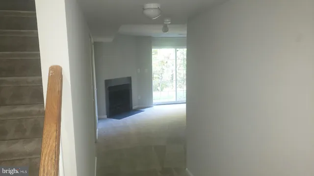 a view of an empty room with a fireplace and a window