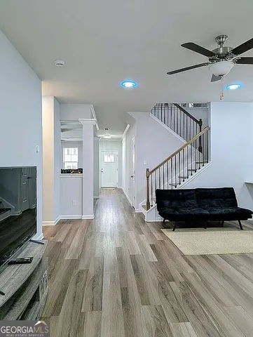 a living room with furniture gym equipment and a ceiling fan