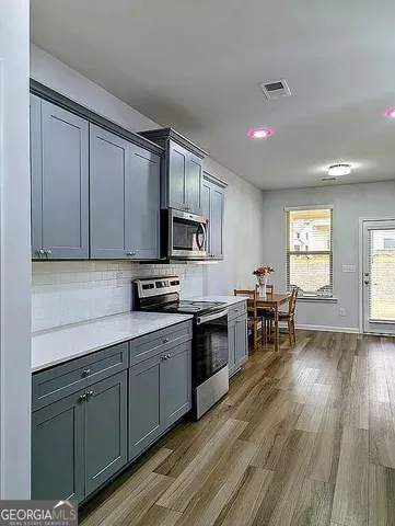 a bathroom with a granite countertop toilet a sink and a window