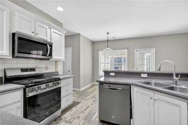 a kitchen with stainless steel appliances granite countertop a sink stove and refrigerator
