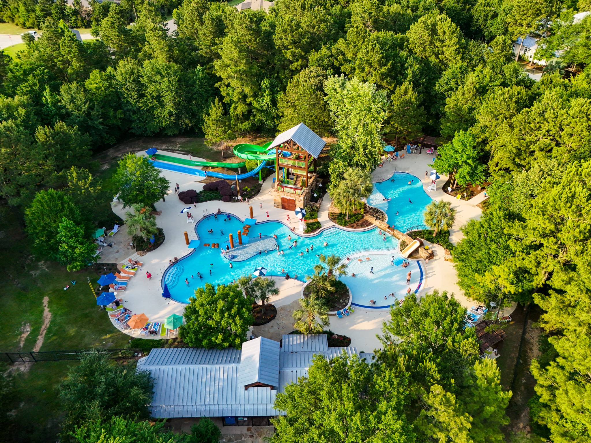 334 Topper Pines Drive Montgomery, TX 77316 - Photo 40 of 49 Closer in at Forest Island, the pool area shows off the resort-style feel with curved swimming areas, lounge space, spray features, and a 42-ft slide tower made for sunny Woodforest days.