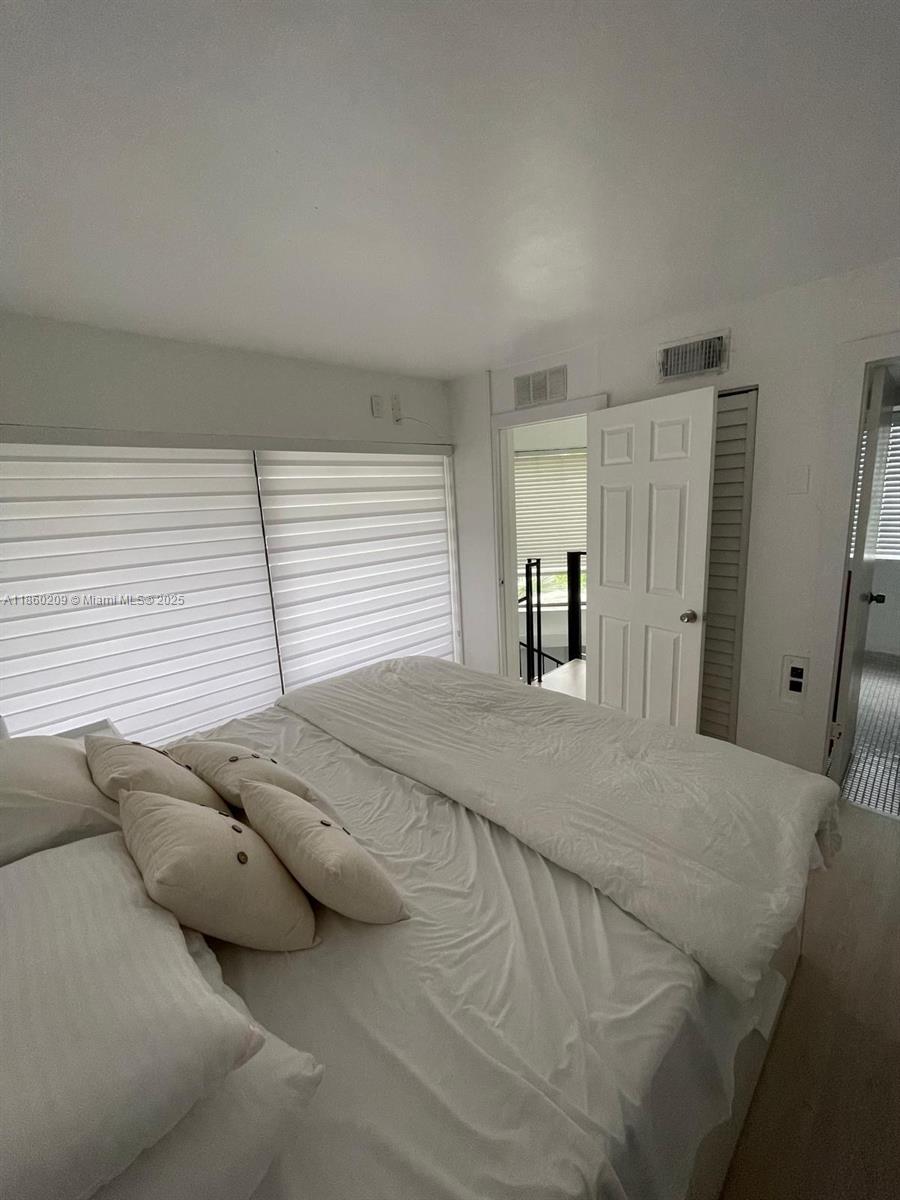 3036 Southwest 27th Avenue, Unit 5 Miami, FL 33133 - Photo 11 of 18 a bedroom with a bed and cabinets