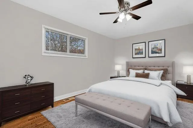 a bedroom with a bed and a lamp on dresser