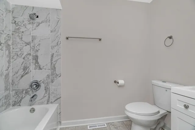 a bathroom with a toilet and a tub
