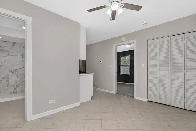 an empty room with fan and entrance