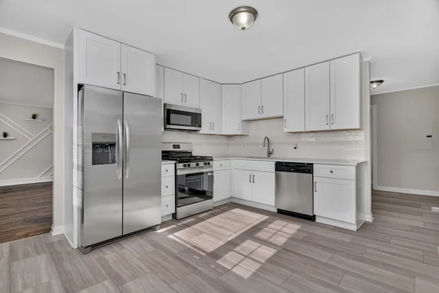 a kitchen with granite countertop a refrigerator stove and sink