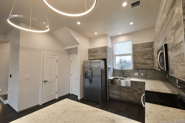 a kitchen with stainless steel appliances a refrigerator a stove a sink a microwave and island