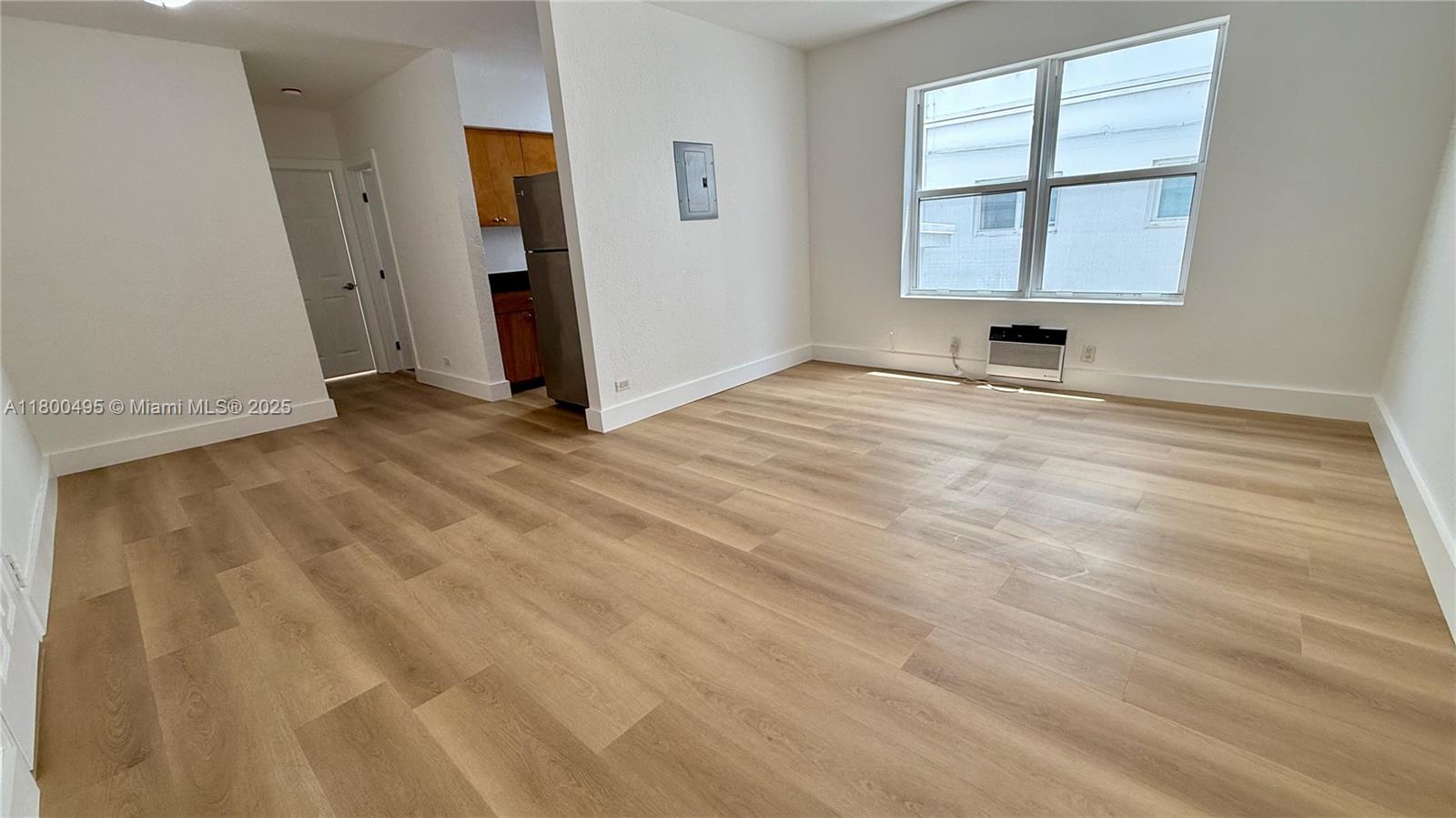 7334 Harding Avenue, Unit 3 Miami Beach, FL 33141 - Photo 21 of 23 an empty room with wooden floor and windows