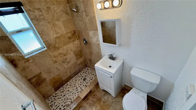 a bathroom with a toilet sink and mirror