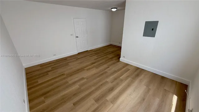 a view of a room with wooden floor and white wall
