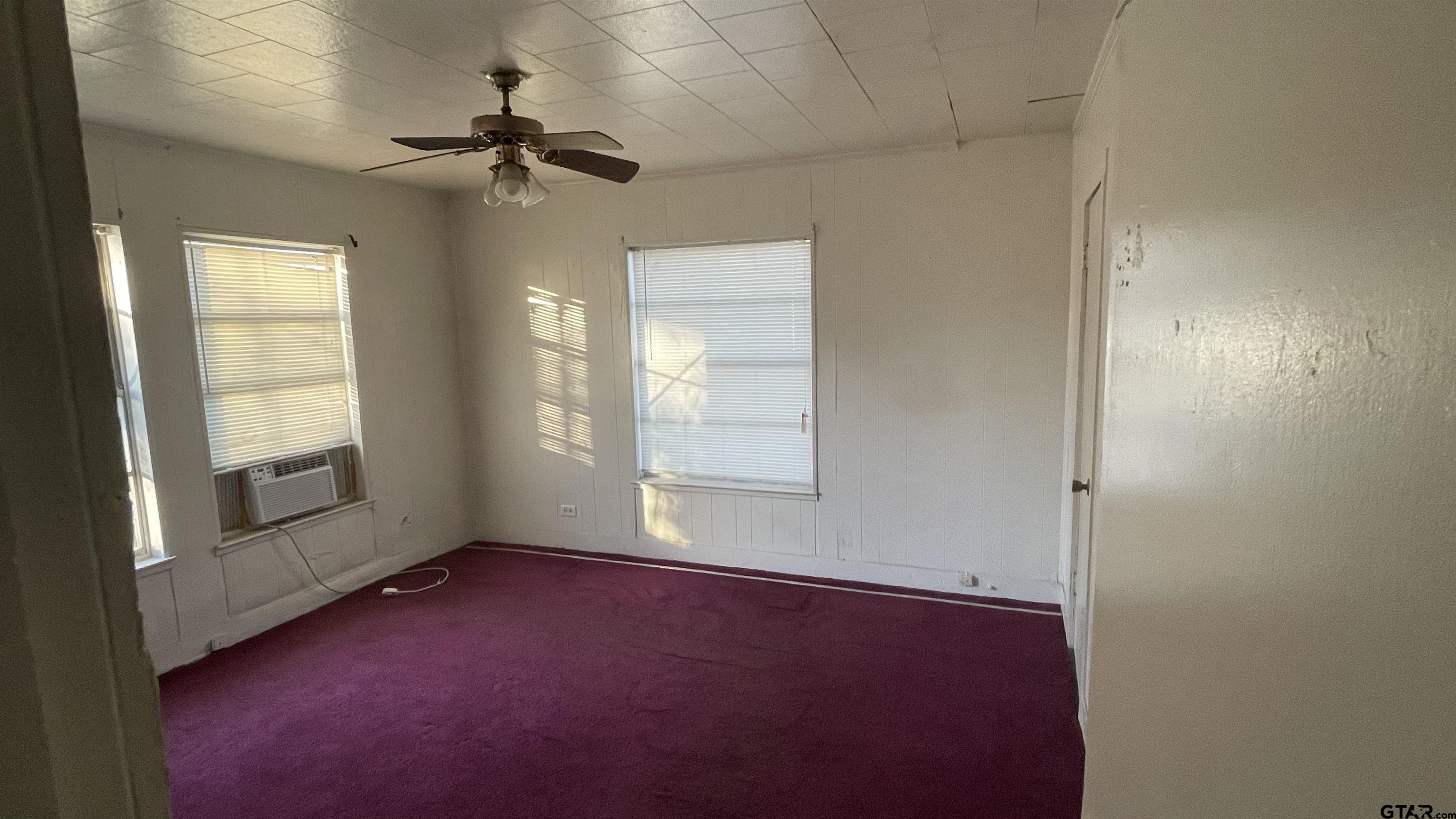 1402 Academy Tyler, TX 75701 - Photo 11 of 14 an empty room with windows and fan