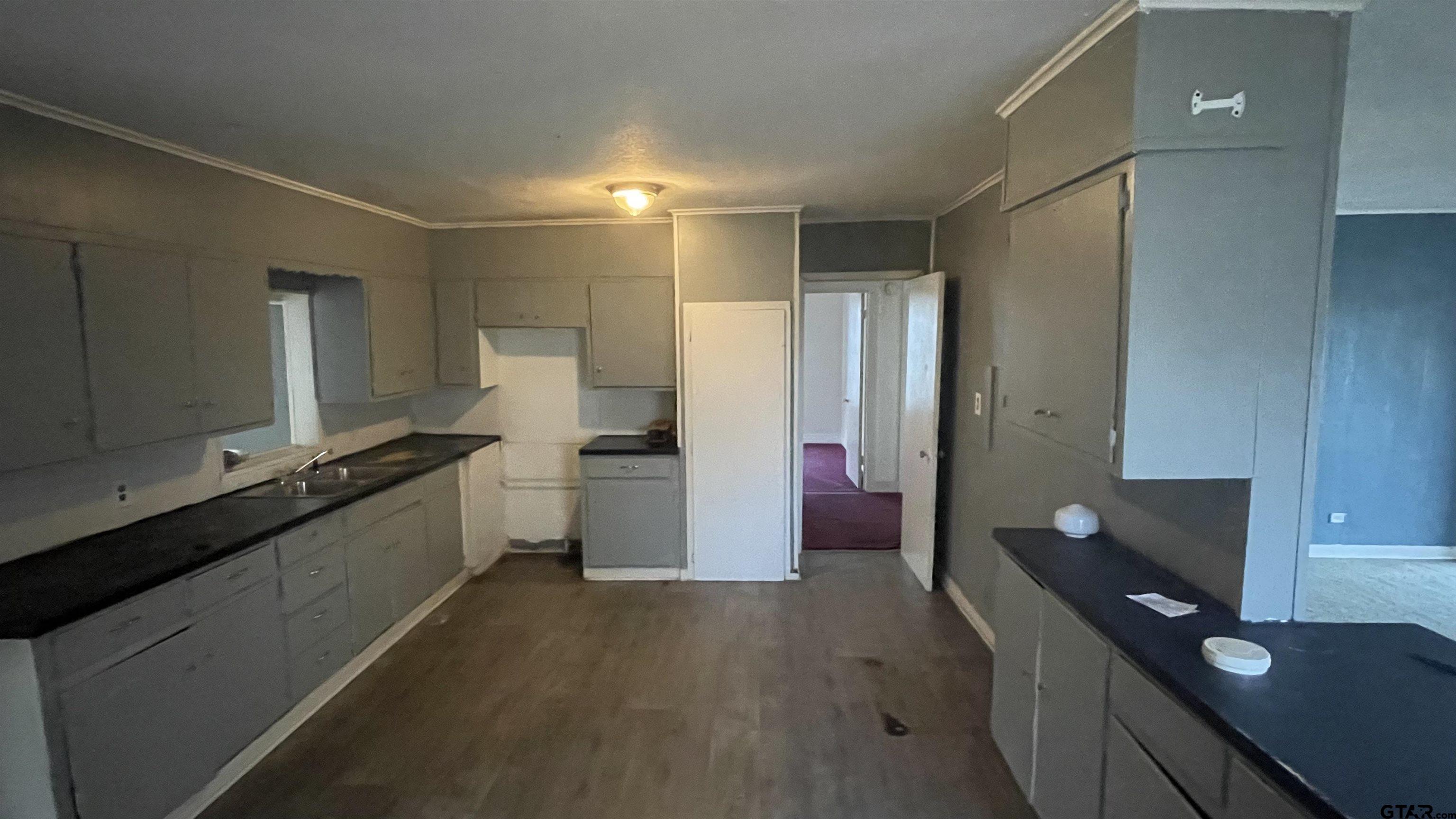 1402 Academy Tyler, TX 75701 - Photo 8 of 14 a kitchen with a sink and white cabinets