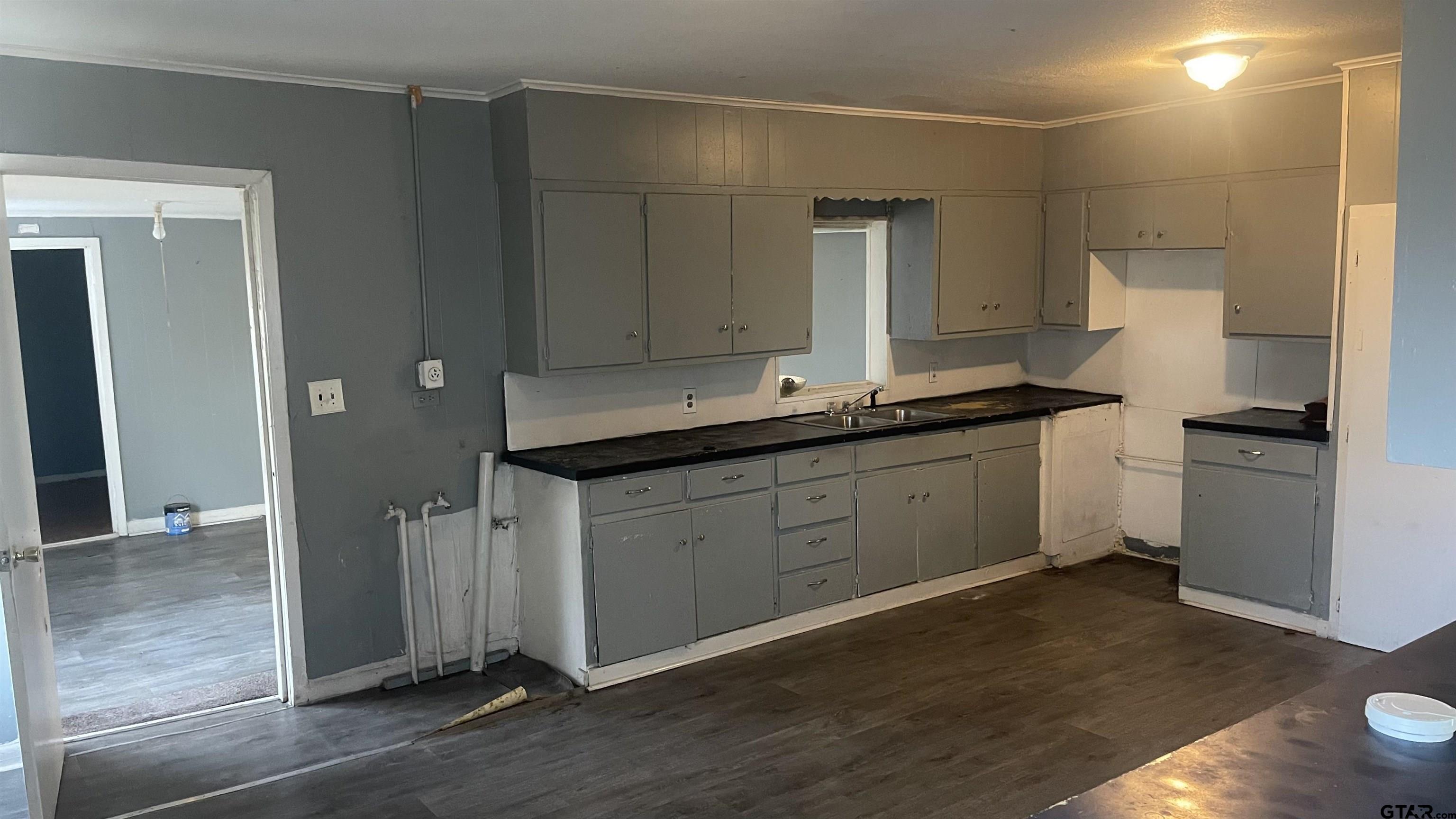1402 Academy Tyler, TX 75701 - Photo 10 of 14 a kitchen with a sink cabinets and wooden floor