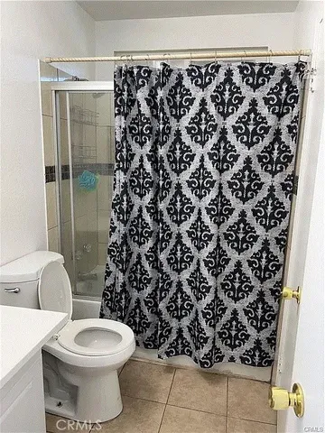 a bathroom with a toilet and a shower curtain