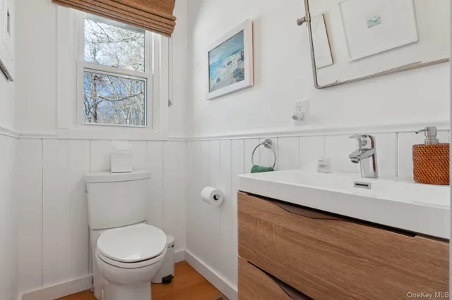 a bathroom with a toilet sink and mirror