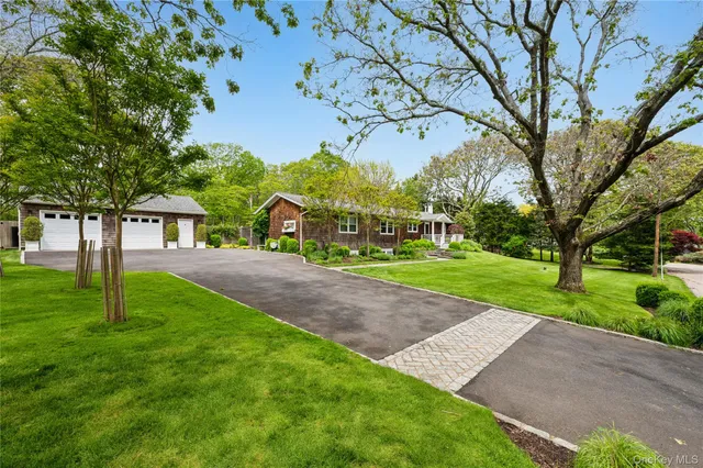 a view of a house with a big yard and large trees
